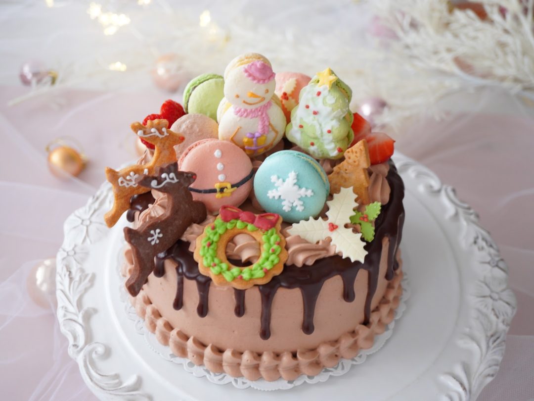クリスマスケーキ　チョコドリップ　サンタ・スンーマン等の可愛いマカロンやトナカイのクッキーなどが飾られているケーキ
